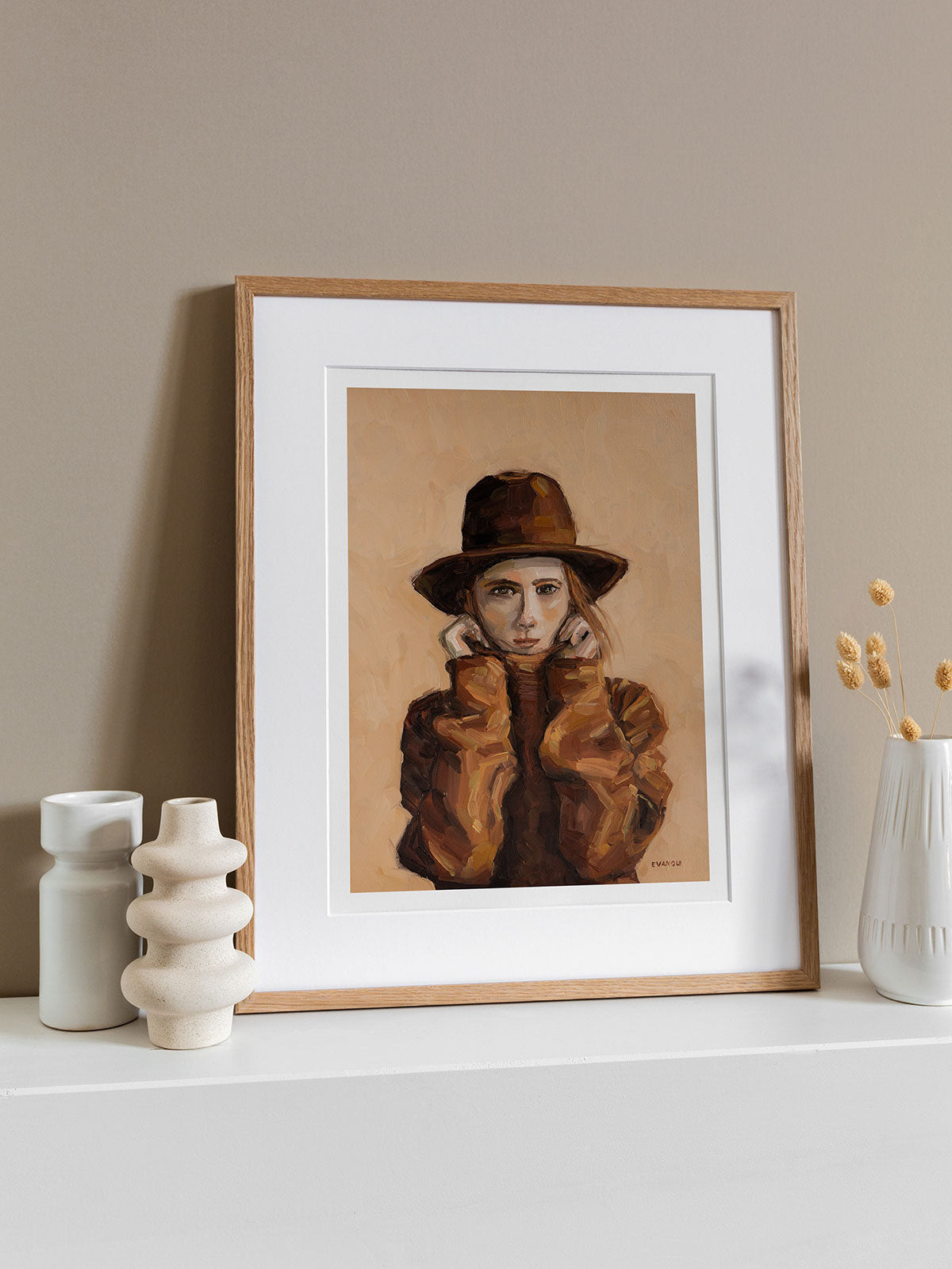 Art print featuring a woman in brown sweater and had, framed in natural wood