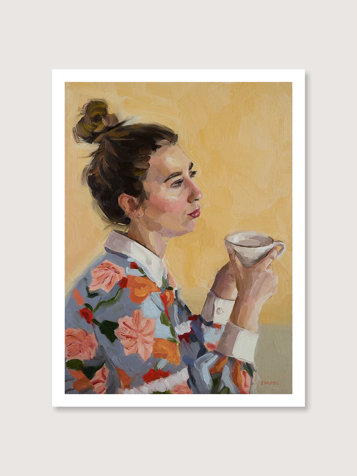 A woman, adorned in a vibrant floral shirt, sits comfortably with a cup of tea in her hands, savouring a moment of calm. 