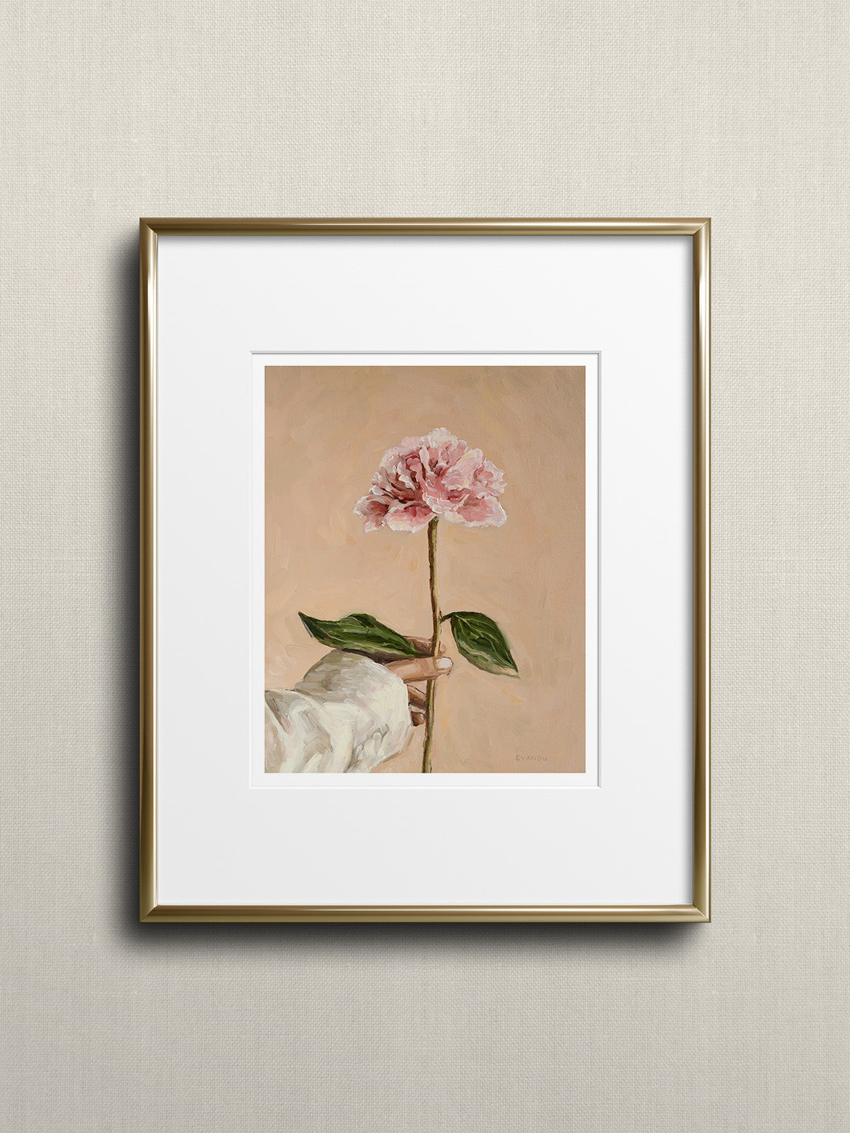 Gold framed art print picturing a hand holding a peony flower.